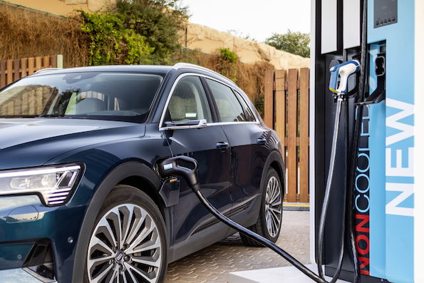  Modelem e-tron koncern Audi dostosowuje elektromobilność do długich tras – także dzięki mocy ładowania, wyróżniającej ten model wśród konkurentów. Audi e-tron to nie tylko pierwszy seryjnie produkowany samochód, który dzięki stacjom szybkiego ładowania można naładować z maksymalną mocą 150 kW. Jego wysoka moc ładowania przez większość cyklu ładowania ustanawia nowe standardy i skraca czas postoju. Dopracowane w najmniejszym szczególe zarządzanie temperaturą akumulatora zapewnia wysoką wydajność procesu zarówno przy niskich, jak i wysokich temperaturach otoczenia.Z reguły ładowanie pojazdów odbywa się w domu albo w miejscu pracy – czas zazwyczaj nie odgrywa tu znaczącej roli, ponieważ samochód długo stoi. Na długich trasach liczy się jednak każda minuta i szybkie ładowanie ma tu podstawowe znaczenie, przykładowo podczas podróży służbowej. Po krótkiej przerwie samochód powinien być ponownie gotów do dalszej jazdy. Projektując Audi e-tron inżynierowie kierowali się tym kluczowym z punktu widzenia samochodu elektrycznego wymogiem. Doskonała krzywa ładowaniaMoc ładowania Audi e-tron wytycza obecnie nowe standardy wśród konkurentów i to nie tylko ze względu na szybkie ładowanie z wysoką mocą (ang. high-power charging) osiągającą nawet 150 kW. Równie ważny co maksymalna moc, jest także wysoki pobór prądu przez akumulator w znacznym zakresie cyklu ładowania. Krzywa ładowania 150 kW w przypadku Audi e-tron charakteryzuje się ciągłością na wysokim poziomie. Oznacza to, że samochód w idealnych warunkach w zakresie od 5 do 70 procent pojemności baterii ładuje się blisko maksymalnej wartości mocy. Następnie inteligentne zarządzanie akumulatorem obniża prąd tak, aby chronić ogniwa litowo-jonowe i w ten sposób wydłużyć żywotność akumulatora. To zupełnie inna koncepcja ładowania od dotychczasowych, w których pełna moc ładowania osiągana jest zazwyczaj tylko chwilowo (peak) i znacznie zmniejsza się już przy wartości 70 procent. Natomiast Audi e-tron nawet przy 80 procentach ładuje się jeszcze z mocą ponad 100 kW.W codziennym użytkowaniu korzyść jest zasadnicza. Aby zapewnić sobie zasięg około 100 km, klient w idealnych warunkach czeka przy kolumnie ładującej mniej niż 10 minut. Próg 80 procent Audi e-tron osiąga po zaledwie 30 minutach. Mimo że z przyczyn technicznych naładowanie pozostałych 20 procent akumulatora litowo-jonowego trwa znacznie dłużej, to pełne ładowanie Audi e-tron przy kolumnie szybkiego ładowania HPC zabiera mniej niż 50 minut. Jest to doskonały wynik wśród konkurentów.Przemyślane zarządzanie temperaturąAkumulator litowo-jonowy w Audi e-tron ma pojemność znamionową 95 kWh i został zaprojektowany z myślą o długiej żywotności. Jego złożone zarządzanie temperaturą to podstawa wyważonej mocy. Chłodzenie cieczą gwarantuje, że temperatura akumulatora także przy wysokich obciążeniach albo niskich temperaturach mieści się w optymalnym zakresie od 25 do 35 stopni Celsjusza. Takie rozwiązanie techniczne zapewnia wysoką moc ładowania i doskonałe parametry jazdy, zapobiegając równocześnie nadmiernemu obciążaniu ogniw. Sercem układu chłodzenia są wytłaczane profile aluminiowe – ich wygląd przypomina kratownicę, która od dołu przyklejona jest do akumulatora. Nowo opracowany klej przewodzi ciepło i łączy jednostkę chłodzącą z obudową akumulatora. Kontakt między obudową i umieszczonymi w niej modułami ogniw zapewnia tzw. gap fitler – żel, który przewodzi ciepło. Jest on wtryskiwany pod każdy moduł ogniwa, wypełniając przestrzeń do obudowy. Dzięki niemu możliwe jest równomierne odprowadzanie oddawanego przez ogniwa ciepła do chłodziwa właśnie poprzez obudowę akumulatora. Takie rozwiązanie jest niezmiernie wydajne. Ponadto odseparowanie elementów przewodzących ciecz chłodzącą i ogniw akumulatora zwiększa bezpieczeństwo całego układu.Kompleksowa oferta ładowaniaObok mocy ładowania i pojemności akumulatora kluczowym czynnikiem dla nieograniczonej i bezproblemowej elektromobilności jest dostępność kolumn ładujących. Audi nie pozostawiło nic przypadkowi również w kwestii infrastruktury. Dysponując własną usługą ładowania e-tron Charging Service, marka z czterema pierścieniami oferuje obecnie dostęp do blisko 100 tys. punktów ładowania w 17 krajach UE. Korzystanie z nich możliwe jest po dokonaniu płatności smartfonem lub kartą. Jednolite dla poszczególnych krajów taryfy umożliwiają łatwe i bezproblemowe podróżowanie bez potrzeby porównywania cen. Na dłuższych trasach klienci Audi mogą na szczególnych warunkach korzystać z kolumn szybkiego ładowania HPC sieci IONITY, która jest stopniowo rozbudowywana i w 2020 roku będzie liczyć już 400 stacji. Kolejne punkty szybkiego ładowania HPC znanych operatorów stanowią na długich trasach uzupełnienie oferty e-tron Charging Service, co pozwala na jeszcze większą elastyczność podróżowania.